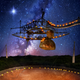 The 305-meter Arecibo telescope, in Puerto Rico, and its suspended support platform of radio receivers is shown amid a starry night. (Image: Danielle Futselaar/Brian P. Irwin/Dennis van de Water/Shutterstock)